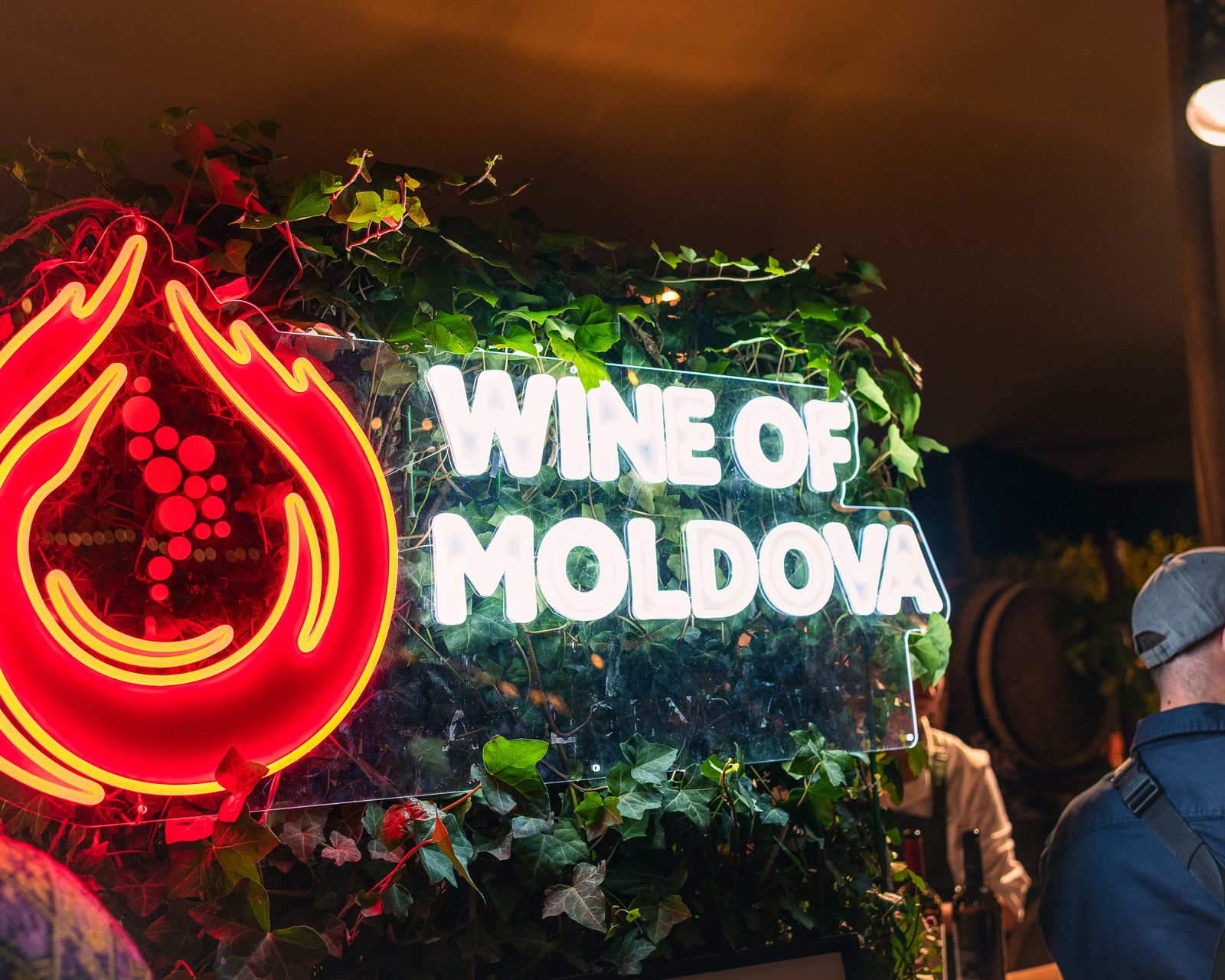 Guests near a Wine of Moldova neon sign at Amsterdam Wine Festival.