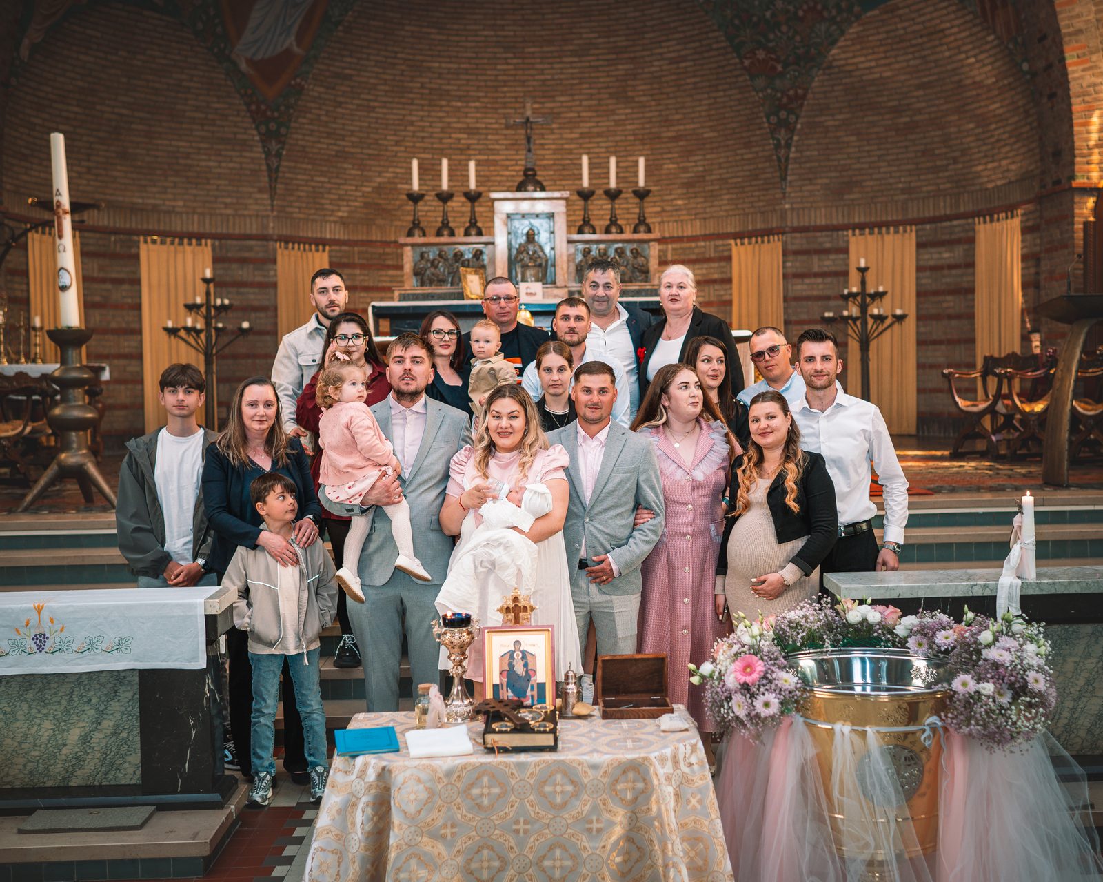 Family group gathered in church after a baptism ceremony.