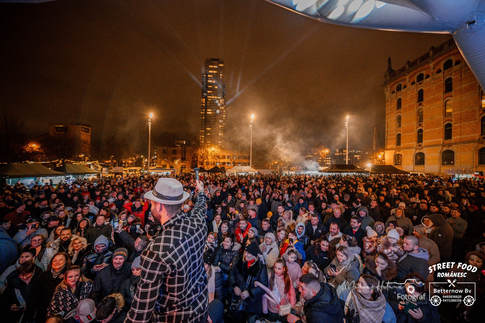 Large nighttime crowd gathered outdoors during Romanian National Day celebrations.
