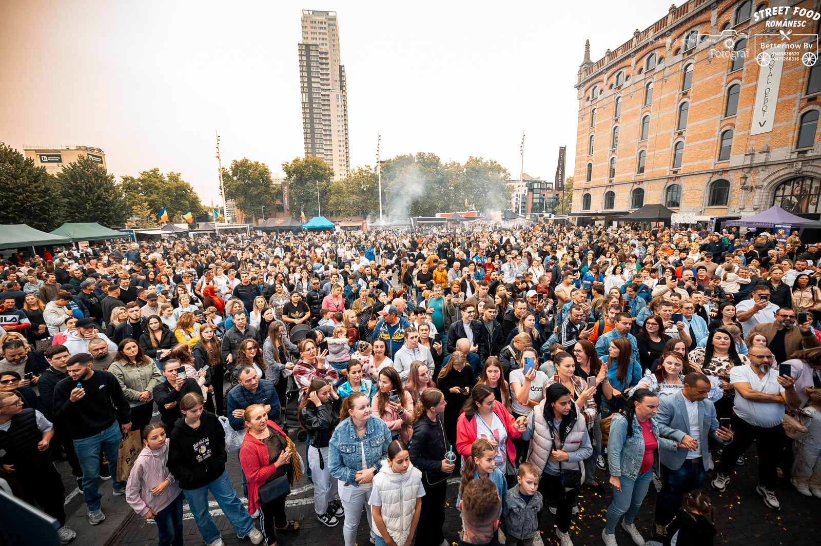 Performers on stage facing a large festival crowd.