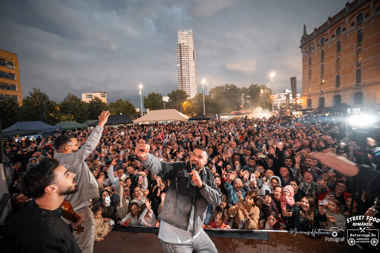 Large outdoor crowd watching a performance at a streetfood festival.
