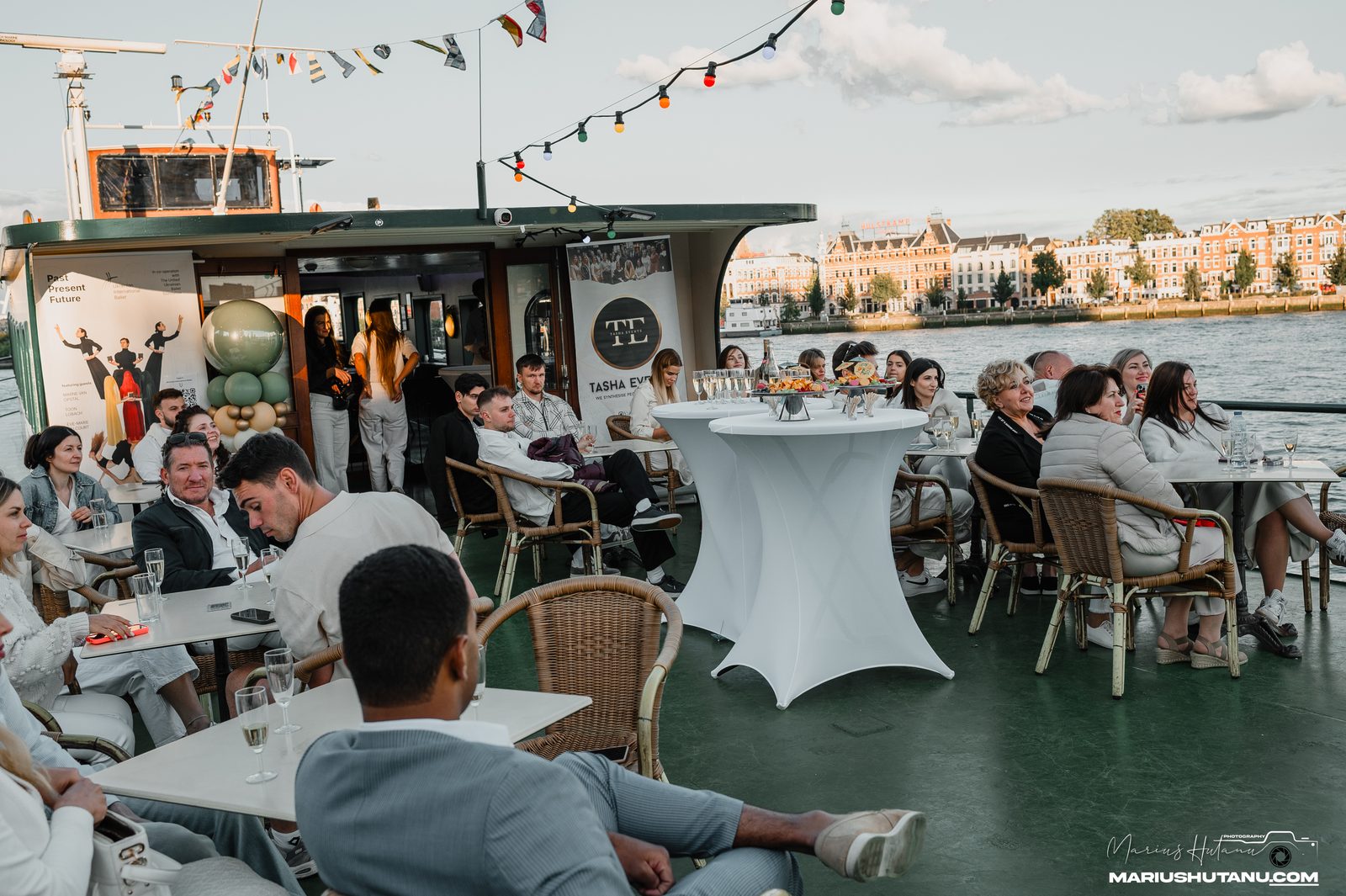 Guests seated on a boat deck during a summer cruise event in Rotterdam.
